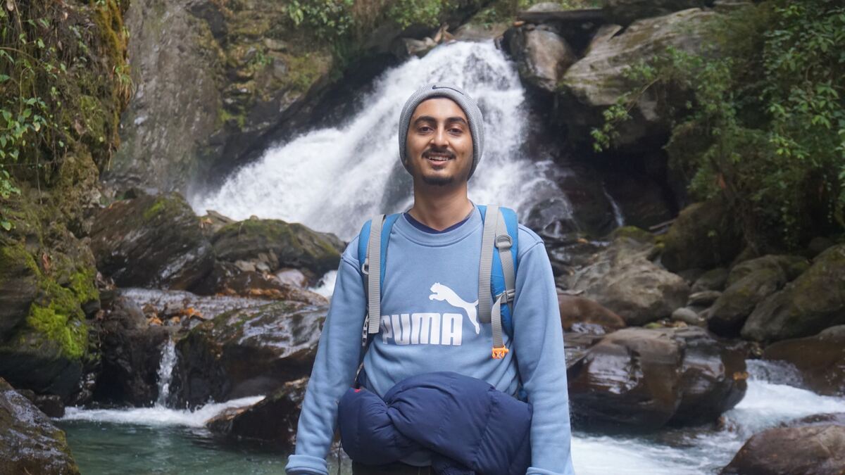 Utsav Paudel at a waterfall while trekking in Nepal